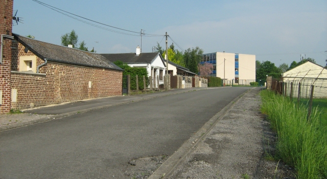 a plain street in france with a big square building at the end